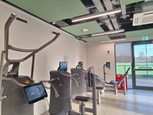 Modern gym room at Stapleford Pavilion featuring LED linear lighting and EGYM strength equipment.